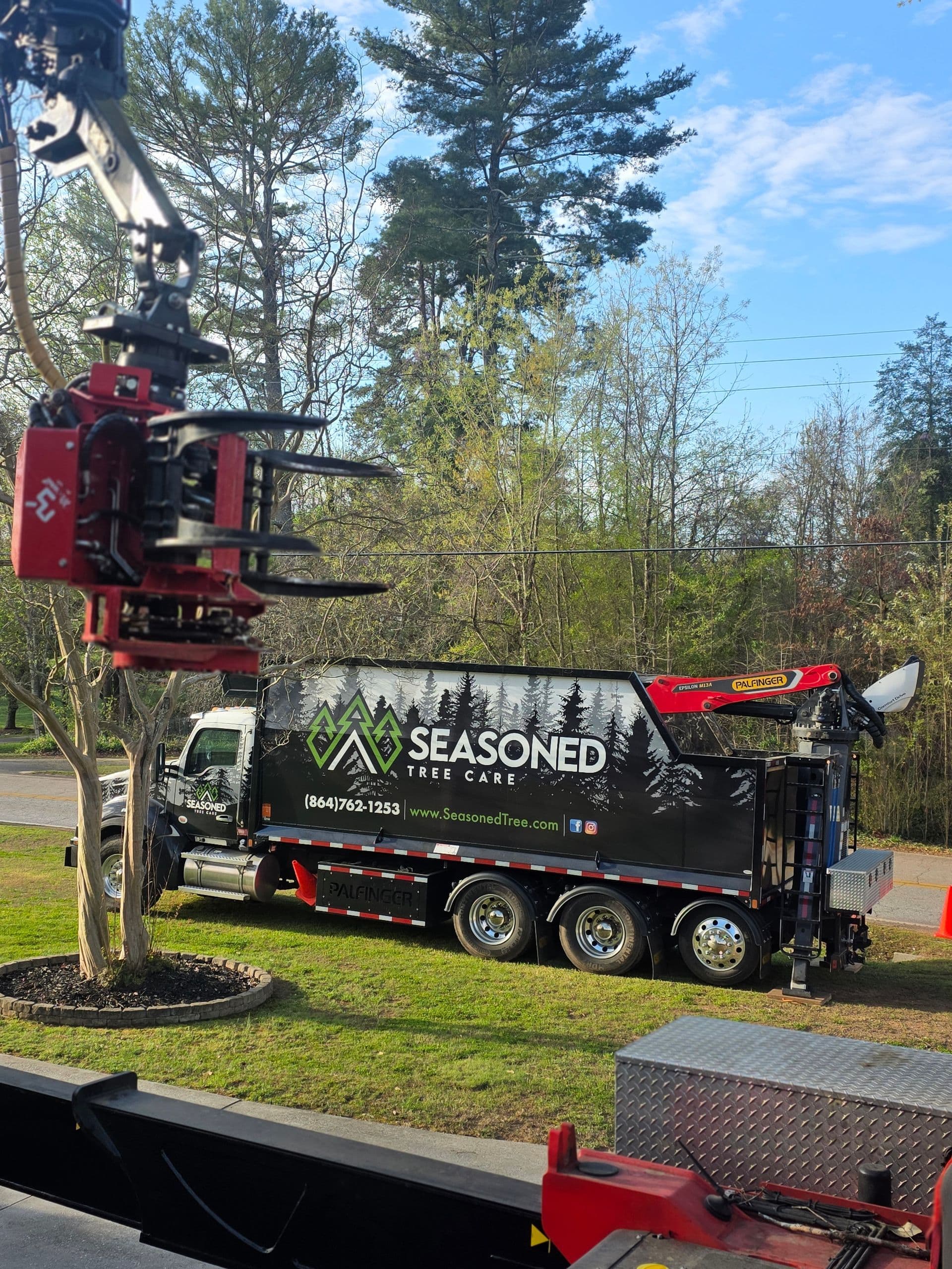 Seasoned Tree Care Palfinger crane lifting a large tree section